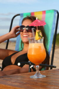 A lady with a smoothie at the beach - sunburn relief recipes