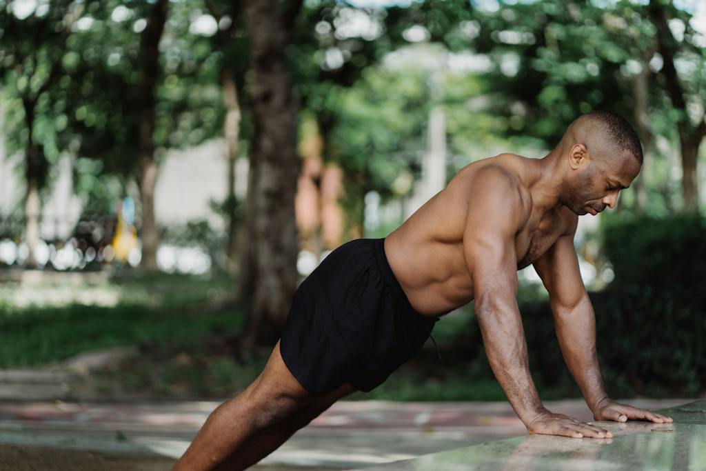 Man in Black Shorts Leaning Forward on the Concrete Surface | building lean muscle