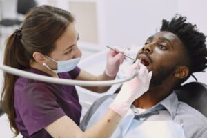 man getting a check up at the dentist | placeholder for Types of Dental Crowns and Cost
