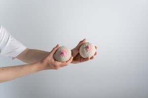 A Person Holding Beige and Pink Knitted Breast | placeholder for breast shrinking during weight loss