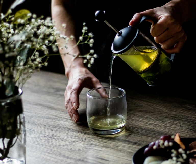 A Person Pouring Yellow Liquid in the Glass | green tea