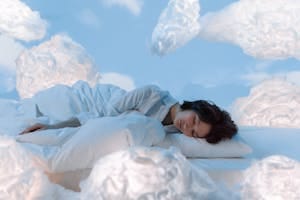 Photo of a Woman Sleeping Near Fluffy Clouds | One Simple Change to Your Night Routine That Melts Fat While You Sleep