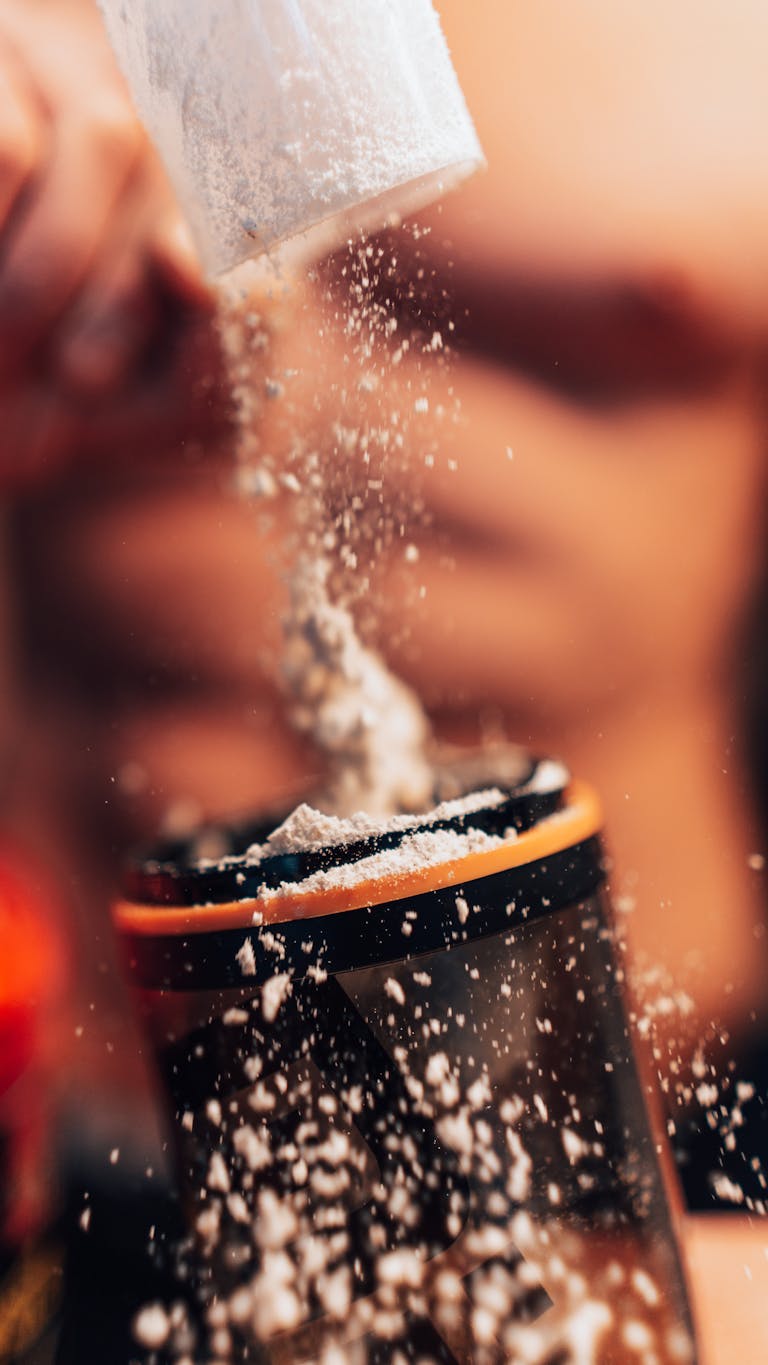 Dynamic shot of protein powder being added to a shaker, fitness concept. | We Tried 17 Protein Powders—These 7 Are Actually Worth Your Money