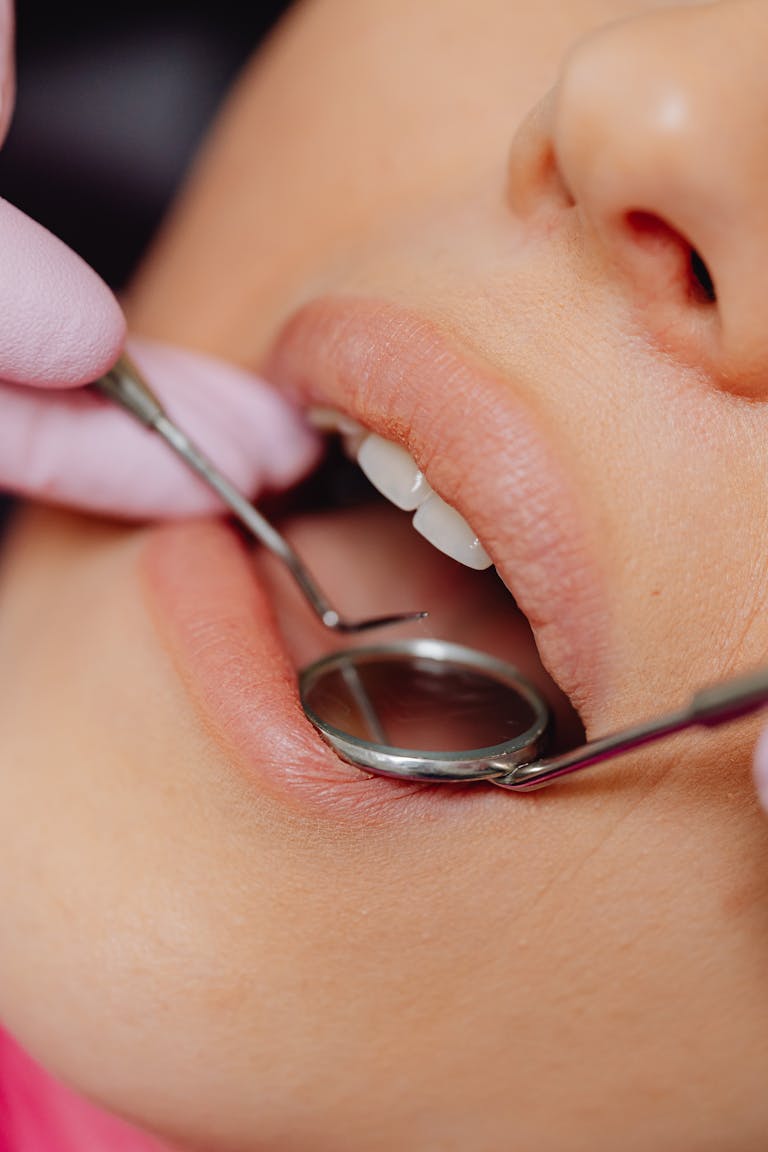 Close-up view of a patient's dental check-up using dental mirror and tools. | Regrow Adult Teeth? Science Says Maybe (Put Down the Denture Glue)