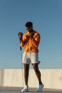 A man performs exercises with resistance bands on a sunny rooftop in Austin, Texas. | Strengthen Every Muscle with This Trainer’s 5-Move Resistance Band Workout