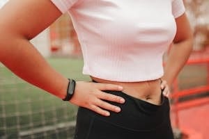 Close-up of a woman wearing a fitness tracker in a sporty setting, emphasizing active lifestyle. | Boost Your Hip Mobility and Lower-Body Strength with This Simple Move, Says a Certified Trainer