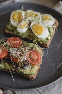 Delicious avocado toast topped with sliced eggs, tomatoes, and sprouts, perfect for a nutritious meal. | Start Your Day Right: 10 Energy-Boosting Breakfasts You Need to Try