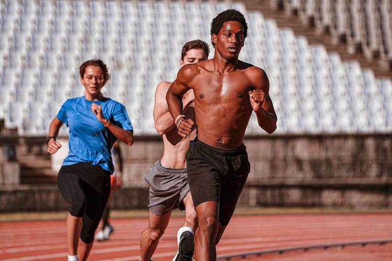 Group of athletes training on an outdoor running track, showcasing fitness and determination. | I Couldn’t Run a 5K in Under 30 Minutes—Until I Stuck to This 2-Month Plan | Unlock Your VO2 Max: The "Norwegian 4x4" Secret Elite Athletes Swear By (Boost Endurance FAST!)