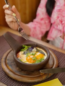 A close-up of a gourmet brunch dish served in a cozy restaurant setting. | The Unexpected Ingredient I Added to My Eggs That Boosted My Protein Intake