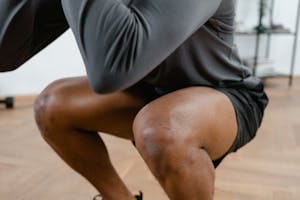 A focused view of a male athlete performing squats in a gym setting, emphasizing fitness and strength. | 4 Exercises That Ended My Knee Pain During Squats
