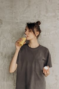 A young woman drinks refreshing juice indoors, embracing a healthy lifestyle. | Everyone Said Collagen Supplements Didn’t Work—But They Were Missing This