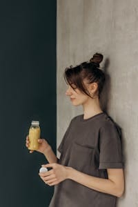 A young woman enjoys a fresh juice drink indoors, promoting a healthy lifestyle. | This is It: The #1 Gut Health Supplement GI Doctors Swear By (Expert Revealed!)
