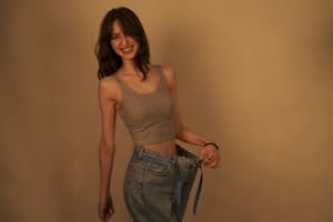 Joyful woman shows success in weight loss by wearing loose jeans. Healthy lifestyle concept. | The No-Gym Workout That Helped a 35-Year-Old Drop 20 Pounds in 2 Months