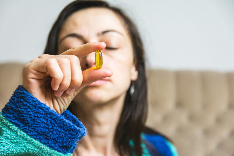 woman holding supplement | Discover how Omega-3s may reverse cellular aging and make your cells 10 years younger. Explore research-backed longevity tips for a youthful life.