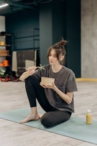 Young woman eating a healthy meal after a yoga workout at the gym. | The Superfood That Helped Me Stay Full After Quitting Ozempic