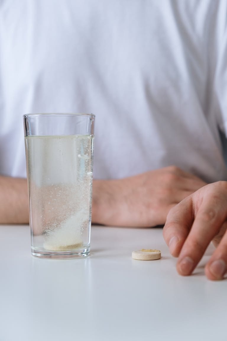 A closer look at an effervescent tablet dissolving in a glass of water, creating bubbles. | Scientists Reveal the Vitamin Duo That Reverses Aging (And Fights Cancer)