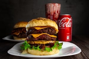 Delicious beef burger with cheese accompanied by a can of Coca Cola. | Is Phenylalanine Secretly Sabotaging Your Diet? Here's the Truth