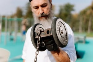 Elderly man exercising with a dumbbell outdoors, focusing on strength and fitness. | The 10 Anti-Aging Strength Moves Every Body Over 50 Should Be Doing