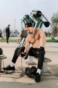 Elderly man lifting dumbbells outdoors, showcasing fitness and a healthy lifestyle. | Want a Younger Brain? Science Says This Workout Combo Beats Crosswords