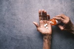Elderly person's hand pouring pills from a bottle, offering ample copy space. | The 4 Worst Supplements for Weight Loss (You’re Probably Taking Them Right Now) | Youth-Stealing Supplements: 2 You MUST AVOID Because They Secretly Age Your Skin!