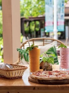 Outdoor scene with pizza and refreshing smoothies, perfect for a tropical dining experience. | The #1 Orange Smoothie to Heal Your Gut (10-Minute Recipe for Less Bloating)