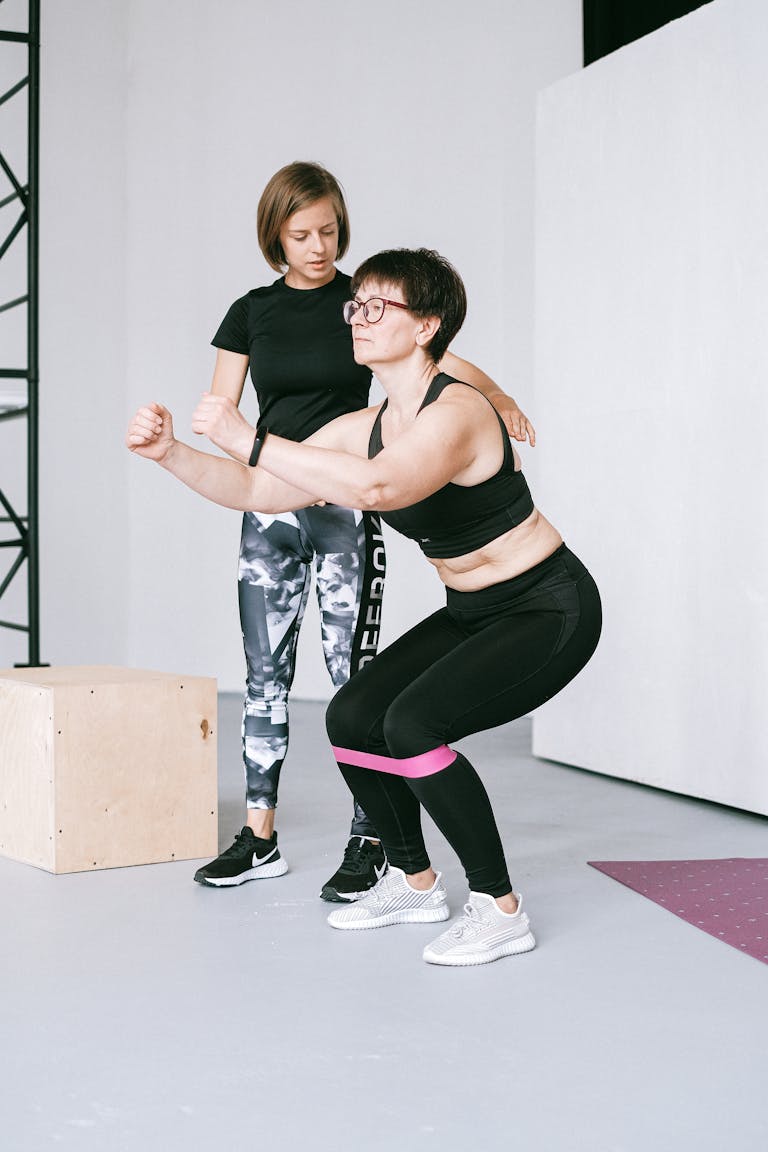 Two women exercising indoors with resistance bands, focusing on balance and fitness. | Doctors Agree: This Is the Best Exercise to Fight Aging and Stay Youthful | Age-Proof Your Balance: 20 Exercises to Stay Steady, Confident, and Fall-Free
