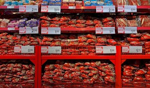 Vibrant assortment of candy bags in a supermarket with signs in Dutch promoting low prices. | No More Candy or Soda? These States Want to Rewrite the Food Stamps Rulebook