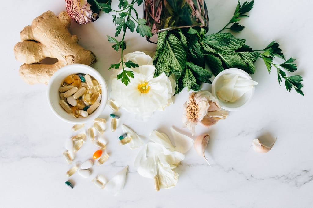 A flatlay of herbal supplements with fresh ginger, garlic, and leaves. | Nature’s Ozempic? 5 Herbs That Burn Fat and Help You Lose Weight Naturally, Says One Doctor