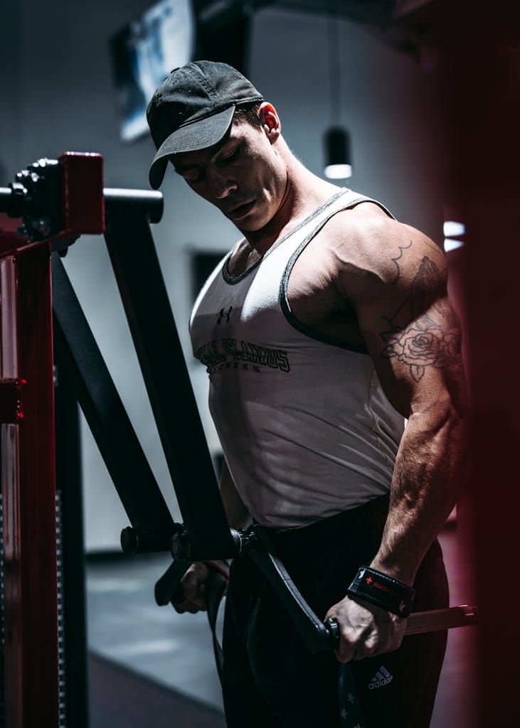 A muscular man exercising with gym equipment, showcasing strength and fitness. | 7 Secret Exercises for Bigger, More Defined Muscles—Are You Missing These?