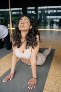 A young woman practicing yoga in a bright studio, focusing on stretching and relaxation. | Can’t Sleep? These 5 Yoga Poses Work Like Natural Sedatives