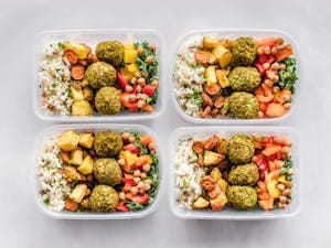 Colorful meal prep containers with falafel, chickpeas, rice, and vegetables for a healthy lifestyle. | Stop Wasting Time: 15 Diet Secrets That Burn Belly Fat 3x Faster in 30 Days