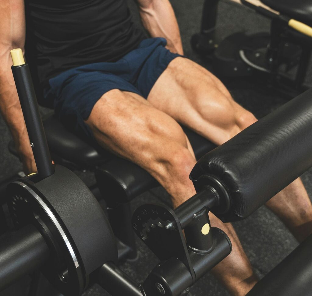 Muscular man working out on a leg press machine indoors, focusing on leg strength. | Build Massive Legs in 30 Minutes—This Routine Hits Quads, Hamstrings, and Calves Hard