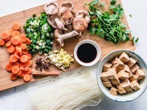 Vibrant assortment of fresh vegetables, herbs, and tofu for an authentic Asian meal preparation. | Vegetarian Muscle Secret: How to Hit 80g Protein Daily (No Powder, No Meat!)