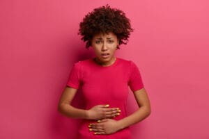 woman holding gut | Bloat Belly Begone! 4 "Healthy" Foods Secretly Wrecking Your Gut & Sabotaging Weight Loss (Experts Reveal!)