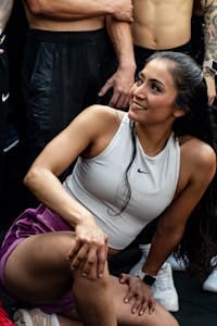 Young woman smiling during an energetic group workout session outdoors. | I Tried 4:3 Intermittent Fasting—Here’s Why It Beat Calorie Cutting by a Mile