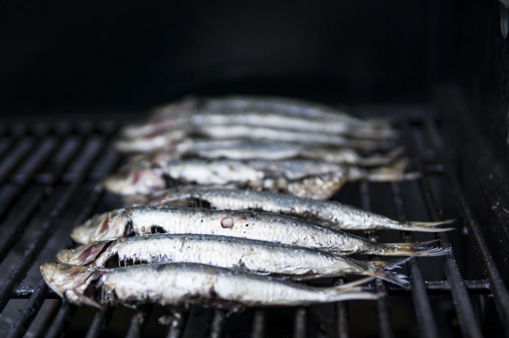 Close-up of sardines being grilled, perfect for healthy seafood cuisine.