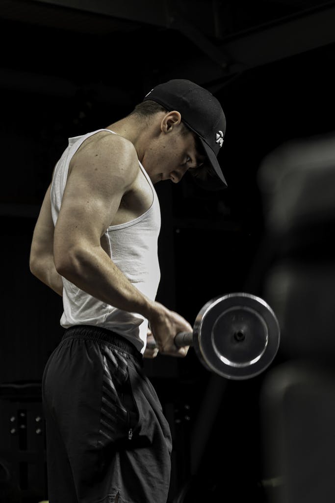Focused young man working out with dumbbells in the gym. | Biceps Breakthrough: 7 Shocking Reasons Your Arms Aren't Growing (And How to Fix It!)