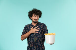 man holding a bucket of chips | Heart Attack Risk Soars: Never Do THIS After a High-Sodium Meal, Say Cardiologists