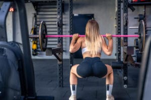 woman squatting | The Only 5 Exercises You Need, According to Top Trainers, for Peak Strength & Fitness