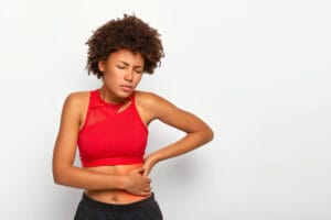 woman with kidney pain | Kidney Stone Nightmare? Avoid These 10 Foods & Eat These 10 to Never Get Them Again