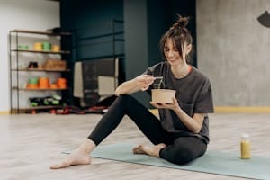 Young woman enjoying a healthy salad after exercising indoors. Promotes a balanced diet and fitness lifestyle. | Unlock "Kidney Power": 10 "Detox Superfoods" That Naturally Cleanse & Protect Your Kidneys (Doctor-Approved!)