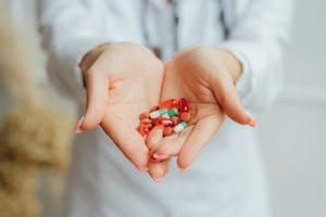 A close-up image of female hands holding diverse colorful pills and capsules. | Doctors Reveal: The 5 Powerhouse Vitamin Combos You NEED for Optimal Health
