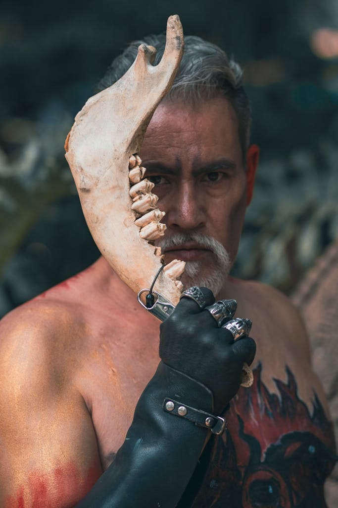 A shirtless elderly man holding an animal bone in a dramatic outdoor setting. | Fight Muscle Loss: The Top Foods Every Older Adult Needs for Lasting Strength.