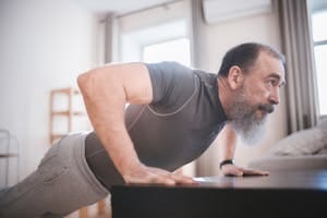 Elderly man performing push-ups in his living room for fitness and health. | The Pushup Test: Can You Out-Perform 90% of People Over 40?