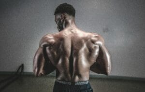 A shirtless man displaying his muscular back, showcasing strength and fitness. | Get Boulder Shoulders: 4 Simple Exercises for Powerful, Defined Delts