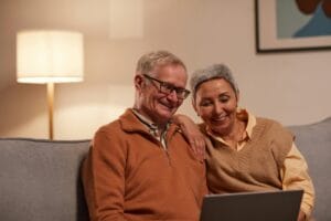 Senior couple enjoying time together on laptop indoors, smiling and relaxed. | Want to Love Your Life After 60? Start These 6 Habits Today