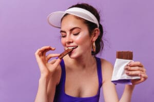 fit woman eating chocolate | Turns Out Eating Chocolate Daily Might Be the Healthiest Habit You’ll Ever Start