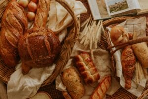 An assortment of artisanal bread displayed in wicker baskets, creating a rustic and warm atmosphere.