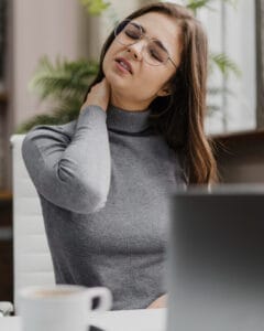 woman with a stiff neck | Experts Say This 4-Minute Chair Yoga Routine Erases Neck Pain and Desk Strain—No Experience Needed