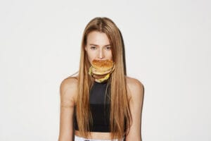 woman eating a hamburger | Craving Fast Food? This Burger Is Shockingly Healthy—and Dietitian-Approved